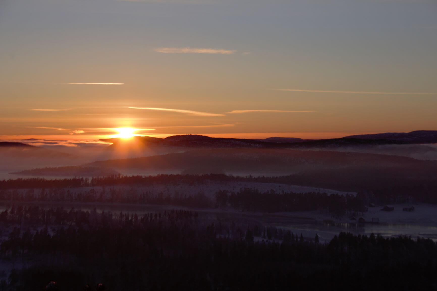 Widok na zachodzące słońce w zimowy dzień na Wysokim Wybrzeżu w Szwecji.